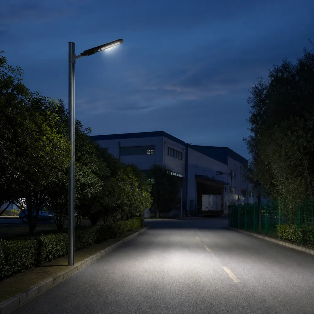 All-in-one LED solar street light installed over an industrial access road at dusk