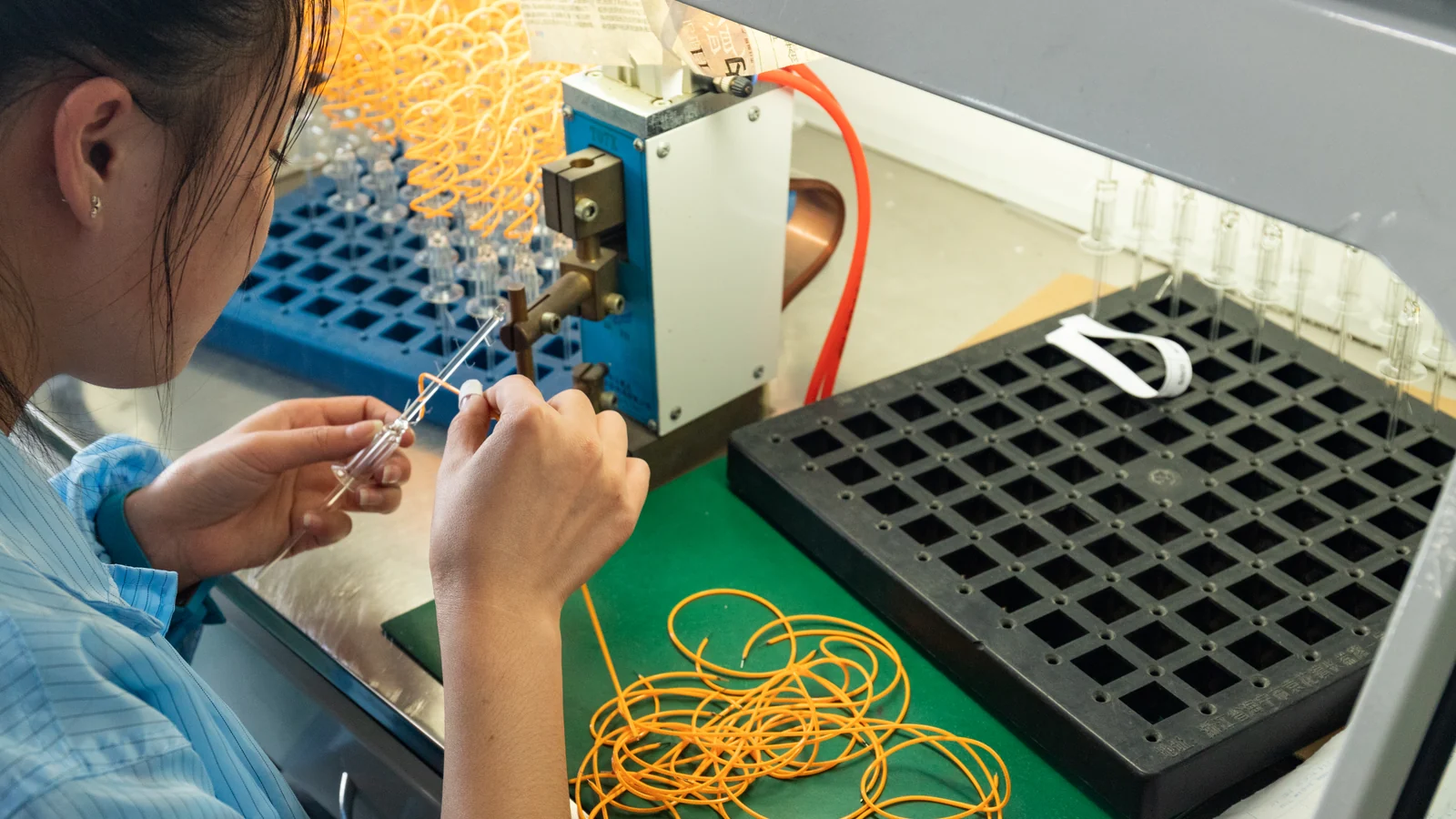 New Lights worker mounting LED filaments during bulb production