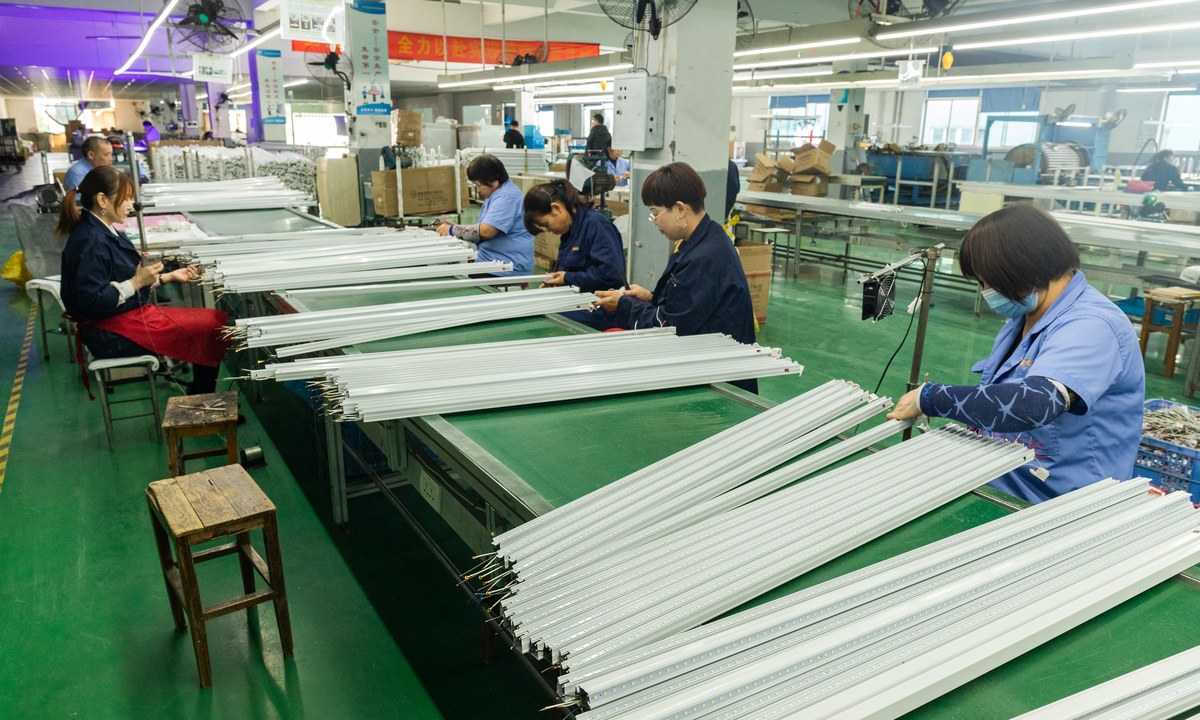 New Lights workers assembling linear LED fixtures on a production line