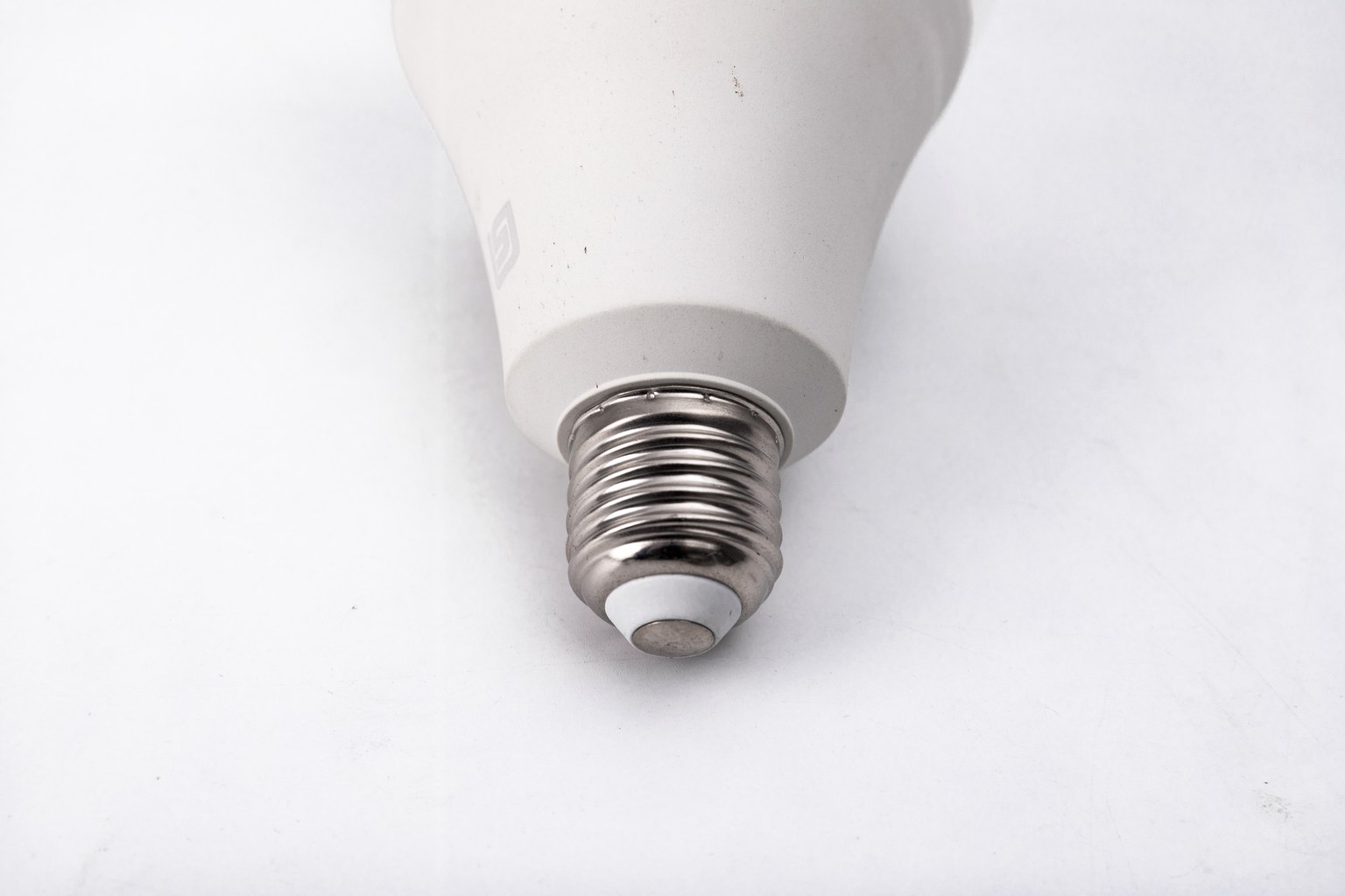 E27 screw base and lower body of a New Lights LED bulb