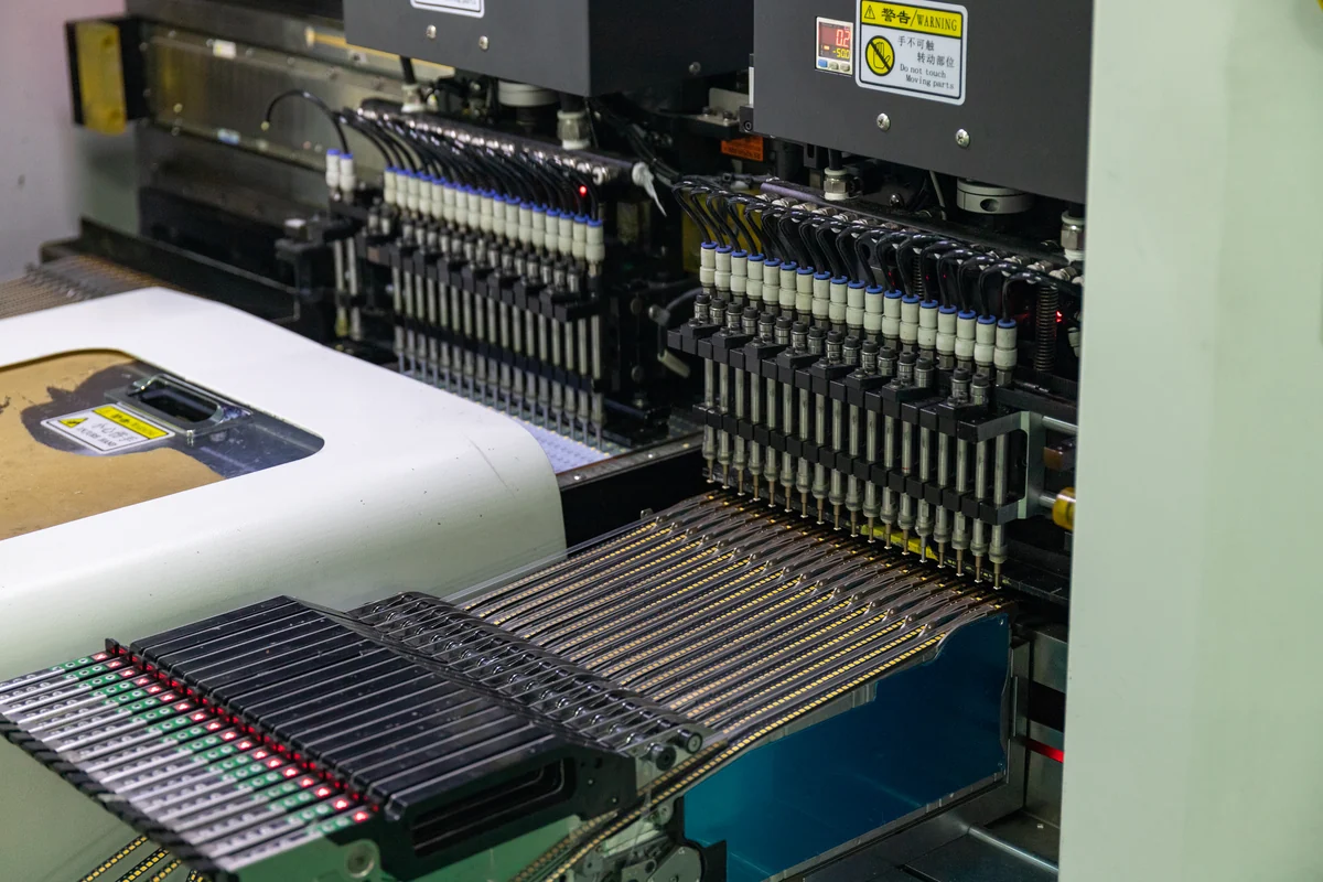 Surface-mount production equipment placing rows of LED packages onto boards at New Lights.